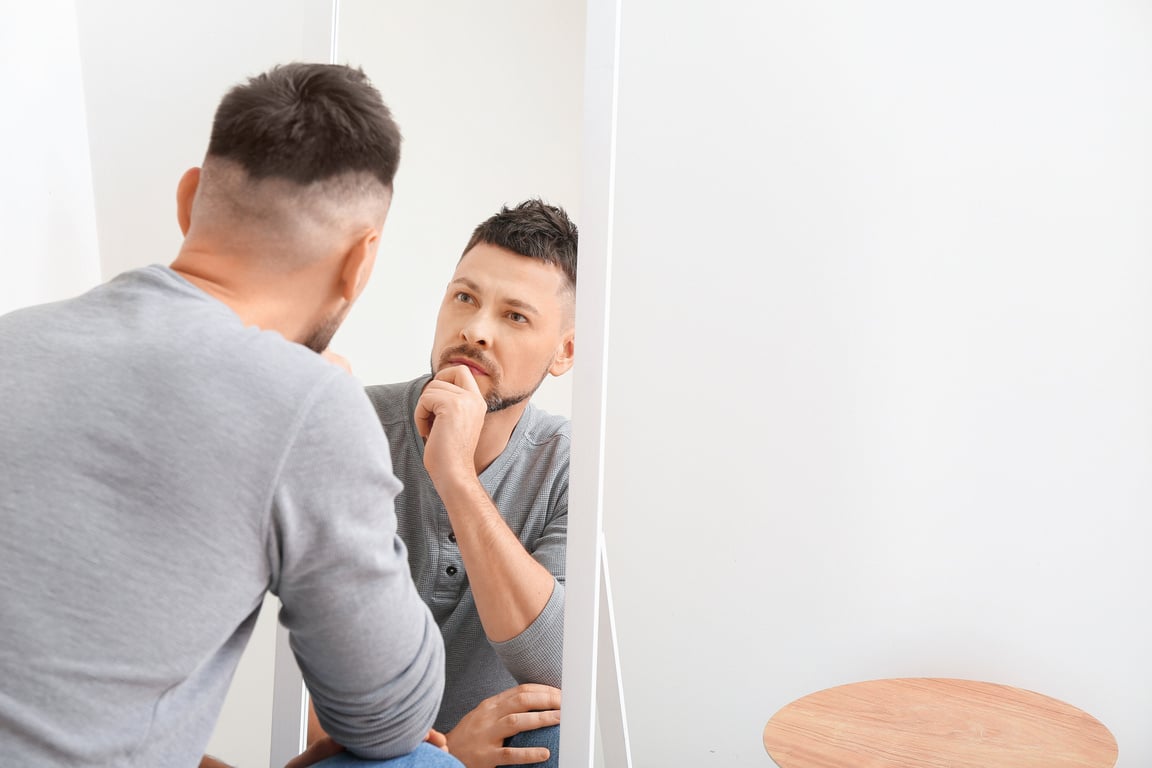 Man Looking in Mirror at Home